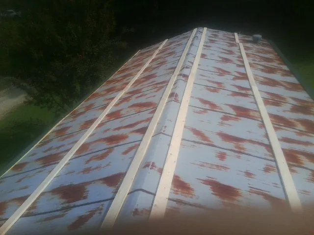 Rusted metal roof panels with new wood purlins before replacement — Storm Damage Roof Repair in Damon by Roofing Brothers